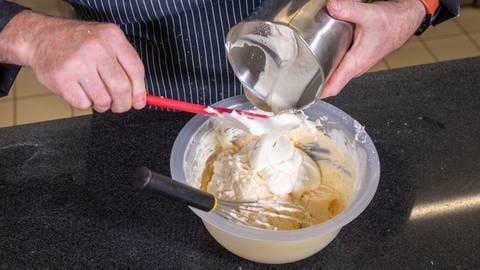 Quark, Zucker, Eigelbe und Puddingpulver werden in eine Schüssel gegeben: Die Füllung für den Käsekuchen mit Pfirsich wird zum Schluss durch die Sahne und den Eischnee ergänzt. (Foto: SWR, Corinna Holzer)