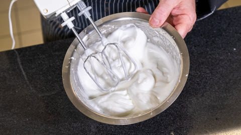 Frisch mit dem Quirl aufgeschlagener Eischnee in einer Schüssel: Die Füllung für den Käsekuchen mit Pfirsich besteht neben Quark aus Eischnee und aufgeschlagener Sahne. (Foto: SWR, Corinna Holzer)