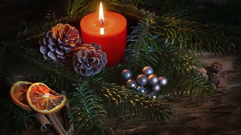 Weihnachtsdeko für den Tisch mit Kerze, Tannenzweigen, Orangenschalen und Tannenzapfen zu Weihnachten. (Foto: picture-alliance / Reportdienste, picture alliance / Rebel/Shotshop | Rebel)