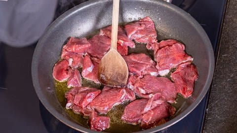 Das Fleisch für das Hirschragout mit Preiselbeeren und Birne wird in einer Pfanne mit Butterschmalz angebraten. (Foto: SWR, Corinna Holzer)