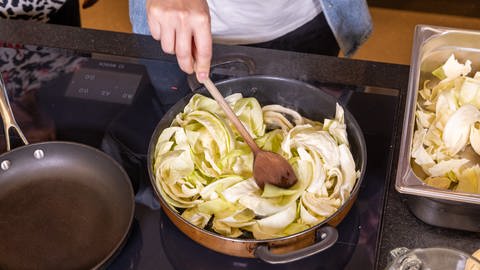 Ilzhöfer kocht für Jordi: Krautfleckerl mit Pilzen und Speck. Die Krautstreifen werden in einen Topf gegeben. (Foto: SWR, Corinna Holzer)