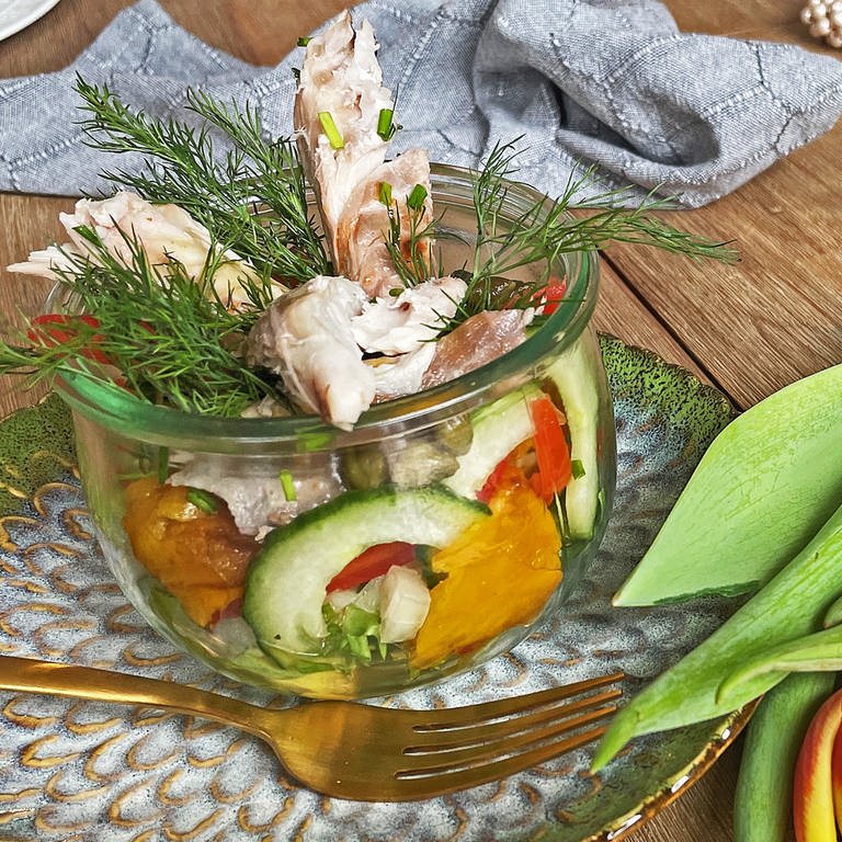 bunter Salat mit Räucherfisch im Glas auf einem grünen Teller mit Gabel, daneben Tulpen  (Foto: SWR, Corinna Lutz)