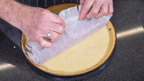 Der Mürbeteig für die Zitronentarte wird nach dem Backen ganz einfach vom Backpapier befreit. (Foto: SWR, Corinna Holzer)