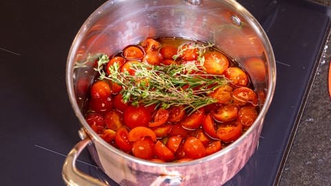In einem Kochtopf befinden sich die Tomaten für die Salsa Sauce. Die Salsa wird dann zu den Grillkartoffeln gereicht.