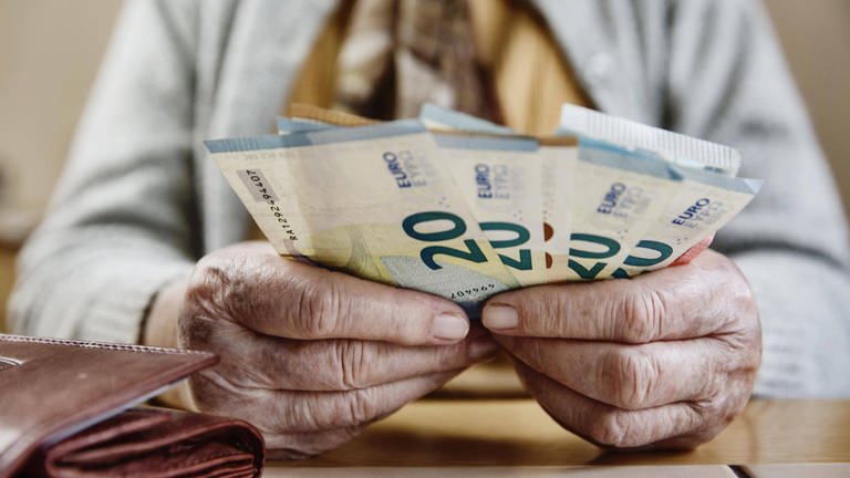 Mehrere 20-Euro-Scheine aufgefächert in den Händen einer Rentnerin. (Foto: IMAGO, imageBROKER/JanxTepass)