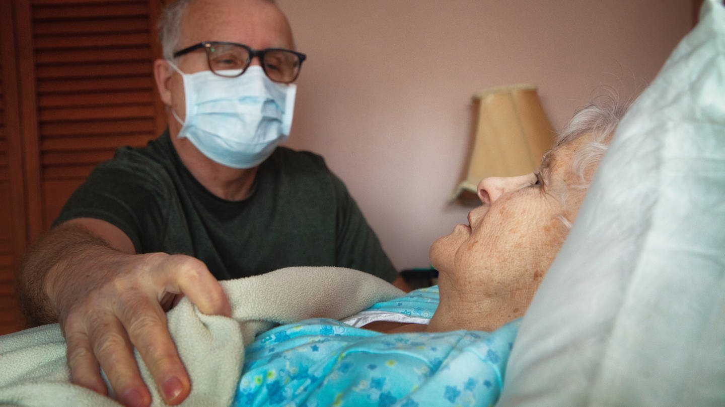 Ein Senior legt besorgt seine Hand auf seine kranke Partnerin. (Foto: Getty Images, Nicolas McComber)