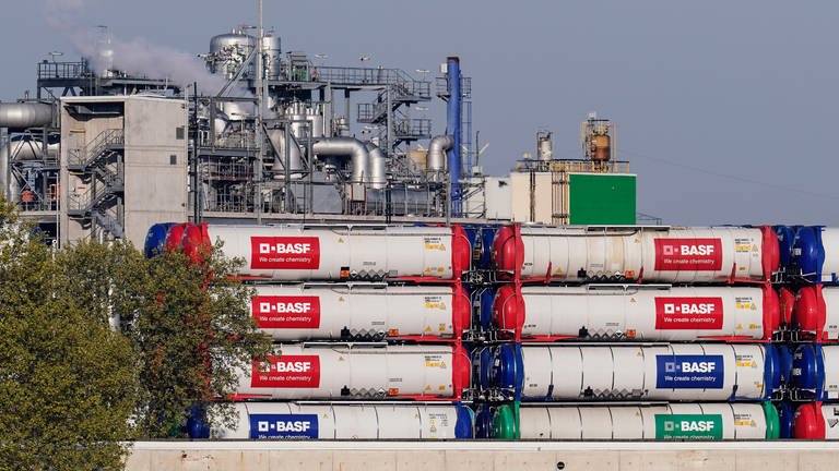 Hinter einem Hafensteg am Rhein stehen auf dem Werksgelände des Chemiekonzerns BASF Behälter mit der Aufschrift "BASF". (Foto: dpa Bildfunk, picture alliance/dpa | Uwe Anspach)
