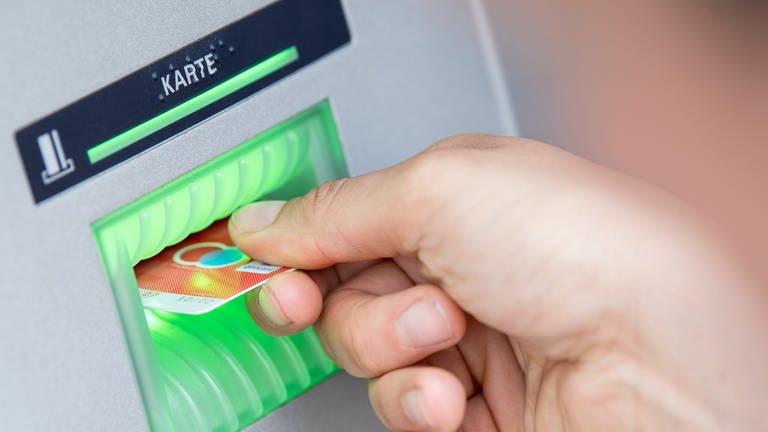 Die Gebühren für Basiskonten sind von Banken und Sparkassen erhäht worden: Bankkundin steckt ihre Girokarte in einen Geldautomaten. (Foto: dpa Bildfunk, picture alliance/dpa | Fabian Sommer)