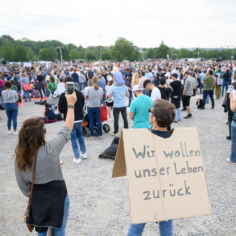 Ein Mann steht auf einer Protestkundgebung mit einem Schild, auf dem "Wir wollen unser Leben zurück" steht  (Foto: picture-alliance / Reportdienste, dpa Bildfunk, Sebastian Gollnow)