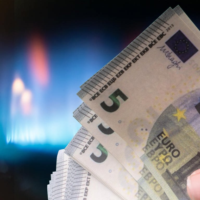 Eine Hand mit Banknoten vor einer Gasflamme. (Foto: picture-alliance / Reportdienste, CHROMORANGE | Andreas Poertner)