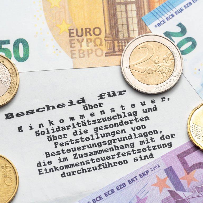 Steuerbescheid vom Finanzamt mit Euro Geldscheinen und Münzen, Einkommenssteuer und Steuererklärung Konzept (Foto: IMAGO, Bihlmayerfotografie)