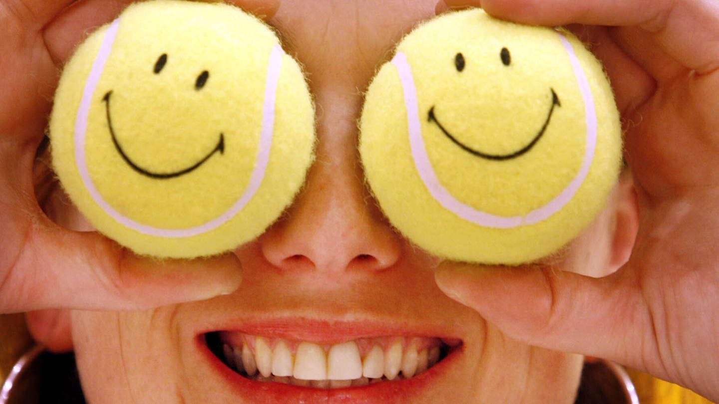 Eine Frau hält sich zwei Tennisbälle mit Smileys vor die Augen (Foto: dpa Bildfunk, picture alliance / dpa | Frank Rumpenhorst)