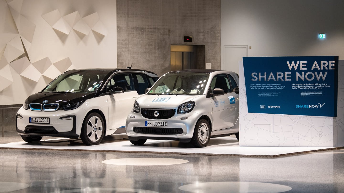 Car-Sharing-Dienst wird an Stellantis verkauft: Ein BMW i3 von DriveNow (l) und ein Smart Fortwo von Car2Go stehen in einer Ausstellung im Mercedes-Benz-Museum neben einem Schild mit der Aufschrift «We are Share Now». (Foto: dpa Bildfunk, picture alliance/dpa | Fabian Sommer)