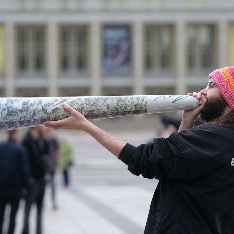 Ein Teilnehmer einer Kundgebung hält einen überdimensionierten Joint in den Händen. Ab dem 1. April 2024 ist Erwachsenen ab 18 Jahren der Besitz von 25 Gramm im öffentlichen Raum erlaubt. (Foto: dpa Bildfunk, Picture Alliance)