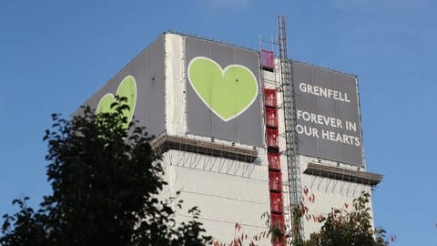 Anlässlich der Veröffentlichung des Berichts hängt am Grenfell-Tower ein Banner mit grünen Herzen und der Aufschrift "Grenfell forever in our hearts" (Foto: dpa Bildfunk, picture alliance/Steve Parsons/PA Wire/dpa)