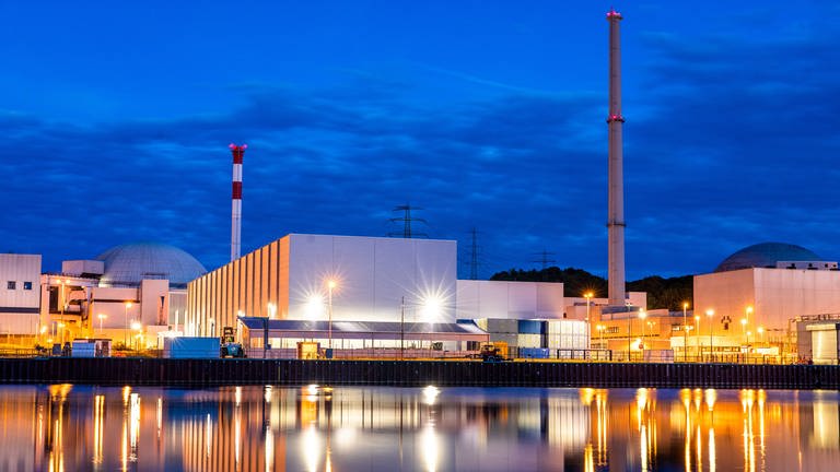 Zur blauen Stunde spiegelt sich das Kernkraftwerk Neckarwestheim im Neckar. Drei Atomkraftwerke sind bundesweit noch am Netz, darunter ist auch Neckarwestheim 2 in Baden-Württemberg. (Foto: dpa Bildfunk, picture alliance/dpa | Christoph Schmidt)