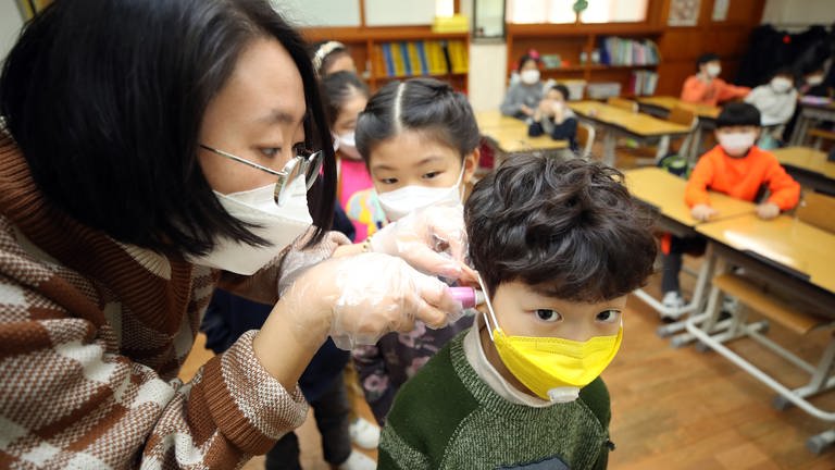 In einer Schule werden Schutzmasken an Kinder verteilt (Foto: dpa Bildfunk, picture alliance/ YNA/ dpa)
