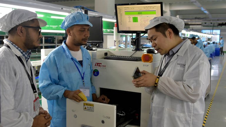 Im neuen Transsion Smartphone-Werk in Narayanganj: Ein chinesischer Ingenieur spricht mit bengalischen Kollegen.