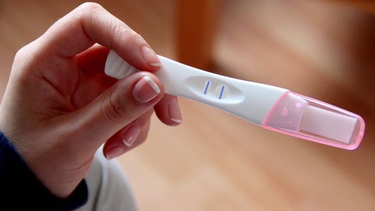 Eine Frau hält einen positiven Schwangerschaftstest in der Hand. Frauen, die ungewollt schwanger wurden, können nach der Empfehlung einer Expertenkommission auf eine Reform des Abtreibungsrechts hoffen.