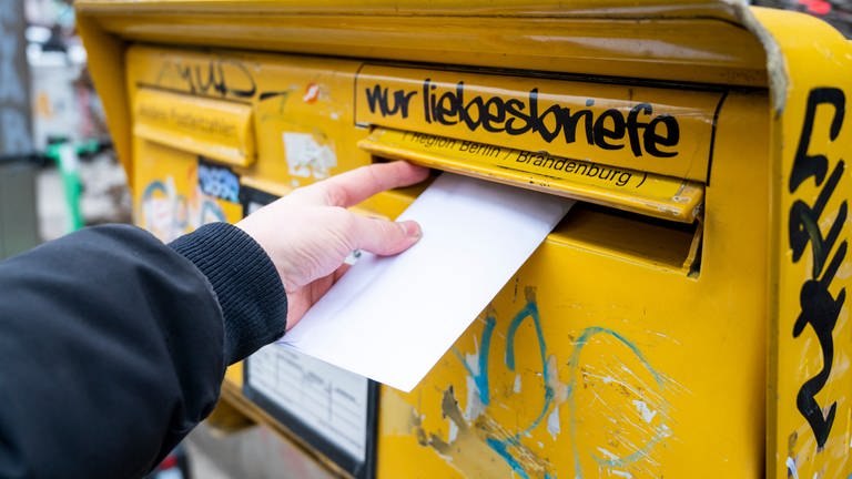 Ein Mann wirft einen Brief in einen Briefkasten.  (Foto: picture-alliance / Reportdienste, dpa Bildfunk, Christophe Gateau)
