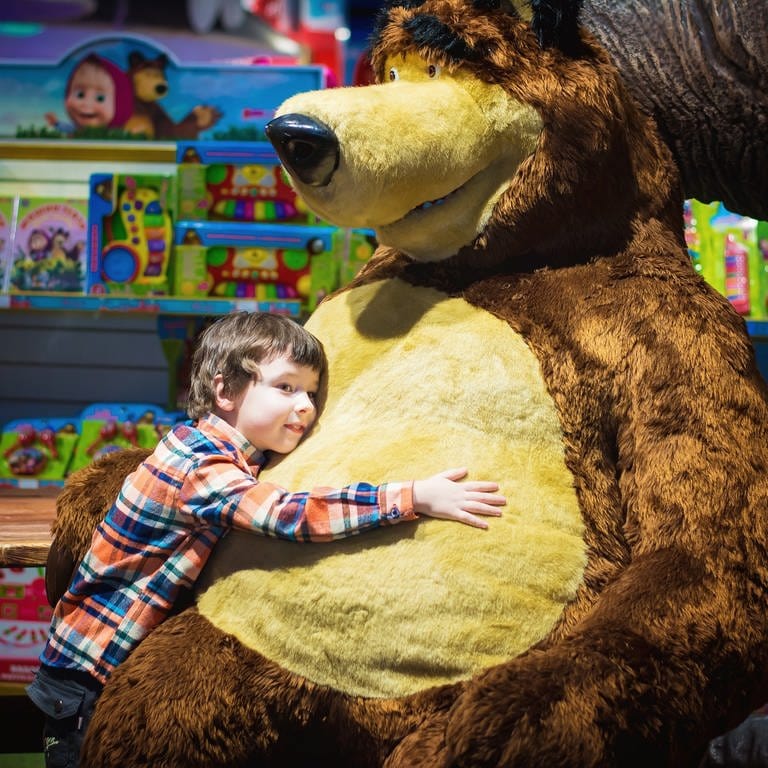 Weihnachtsgeschäft 2022: Ein Junge umarmt einen riesigen Bären in einem Spielzeugladen.  (Foto: pixabay (child-shop-shopping-center-holiday-2936975))
