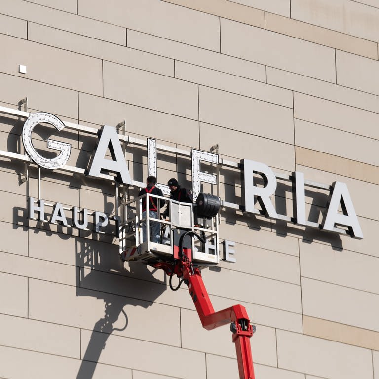 Arbeiter montieren ein "Galeria"-Logo - bald könnte es wieder abgenommen werden.