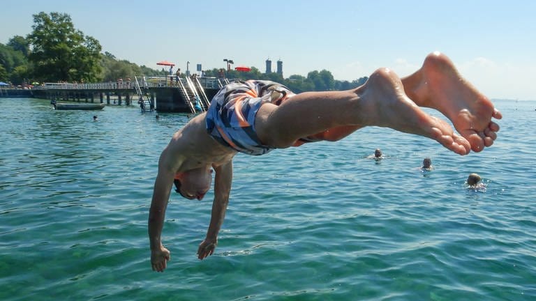 Ein Badegast springt im Strandbad vom Floß in den Bodensee. (Foto: picture-alliance / Reportdienste, Picture Alliance)