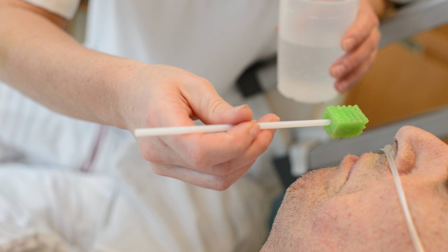 Befeuchten und Reinigung des Mundes eines schwerstkranken Patienten auf einer Palliativstation in einem deutschen Krankenhaus (Foto: IMAGO, epd)