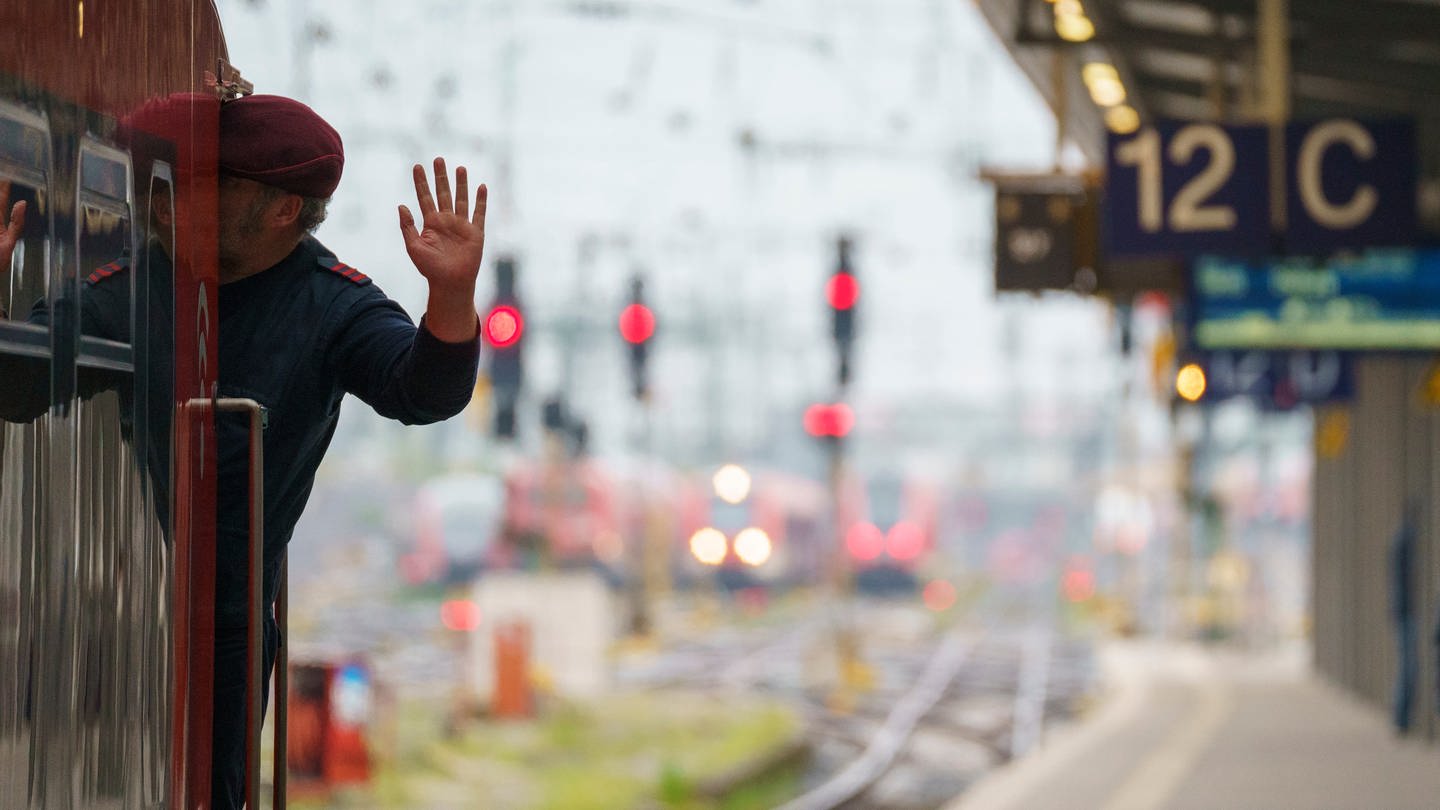 Ein Lokführer gibt kurz vor Abfahrt eines Zuges ein Handzeichen. (Foto: dpa Bildfunk, picture alliance/dpa | Andreas Arnold)