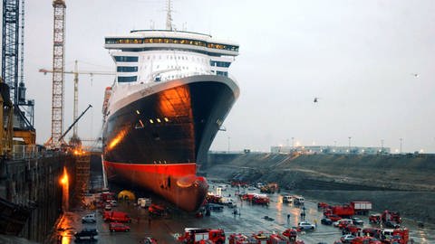 Feuerwehrautos stehen am 15.11.2003 auf dem Werftgelände von Saint-Nazaire um den Luxusliner "Queen Mary 2".