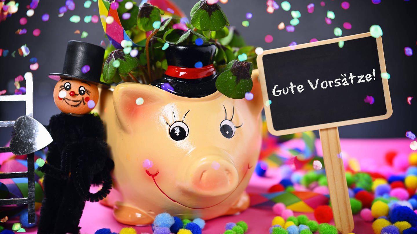 Glücksschwein mit Kleeblättern, Schornsteinfegerfigur und Schild mit Aufschrift Gute Vorsätze! (Foto: IMAGO, Christian Ohde)