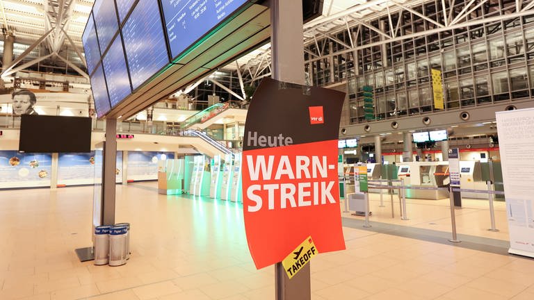 Ein Plakat mit der Aufschrift "Warnstreik!" hängt im Terminal 2 am Flughafen Hamburg (Foto: dpa Bildfunk, Picture Alliance)