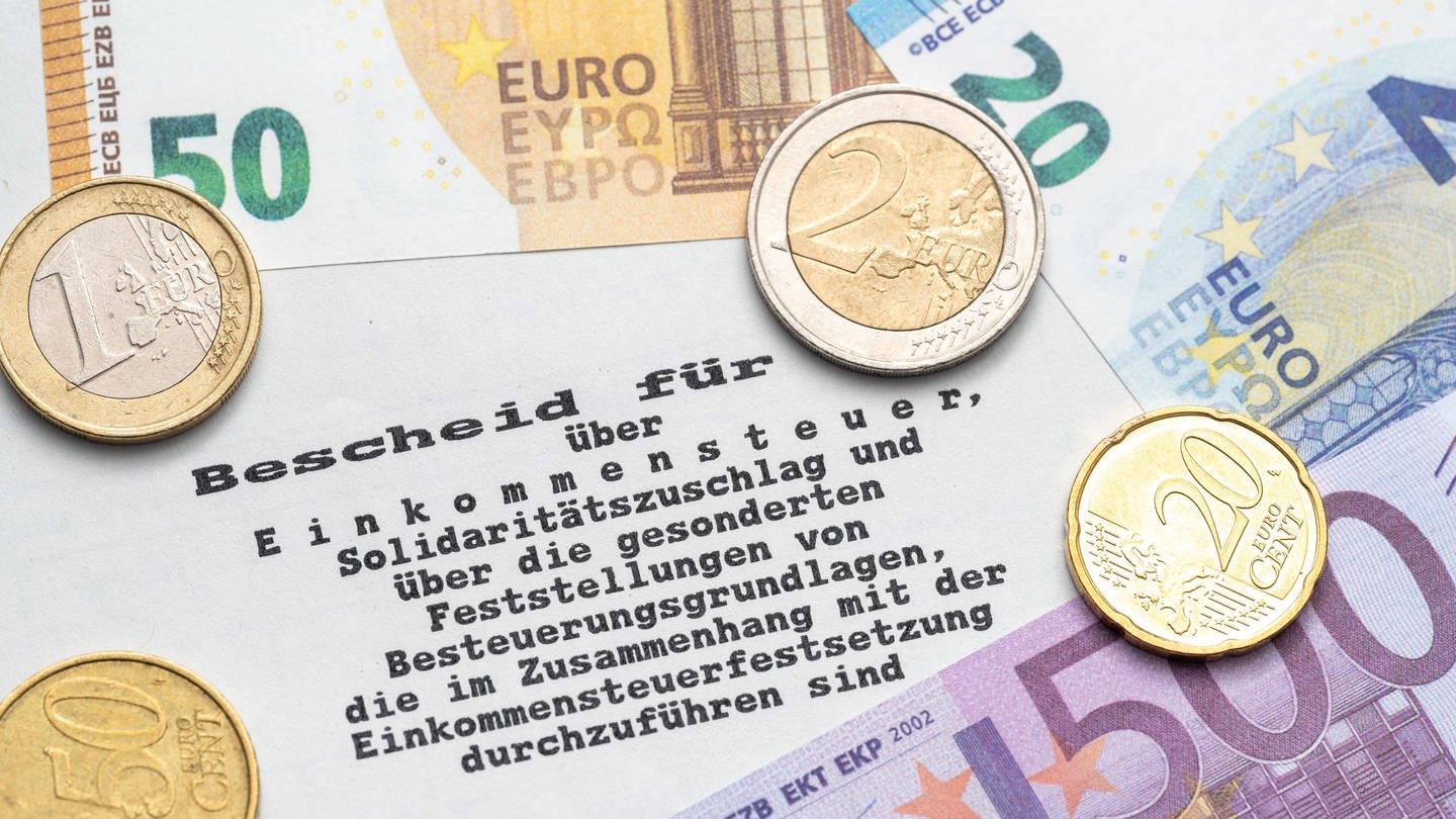 Steuerbescheid vom Finanzamt mit Euro Geldscheinen und Münzen, Einkommenssteuer und Steuererklärung Konzept (Foto: IMAGO, Bihlmayerfotografie)
