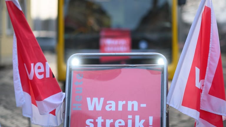 Symbolbild: Ein Schild "Warnstreik" steht vor einem Bus der Dresdner Verkehrsbetriebe (DVB) während des Warnstreiks im öffentlichen Nahverkehr. (Foto: dpa Bildfunk, Robert Michael/dpa (Symbolbild))