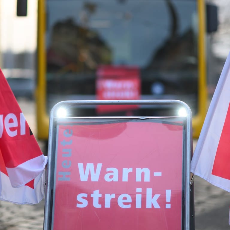 Symbolbild: Ein Schild "Warnstreik" steht vor einem Bus der Dresdner Verkehrsbetriebe (DVB) während des Warnstreiks im öffentlichen Nahverkehr. (Foto: dpa Bildfunk, Robert Michael/dpa (Symbolbild))
