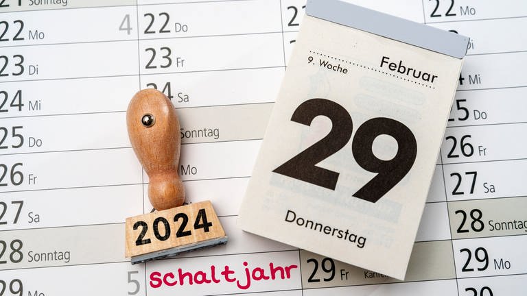 Kalender mit dem Datum 29. Februar neben Stempel mit Aufschrift 2024 und Kalender mit Aufschrift Schaltjahr 