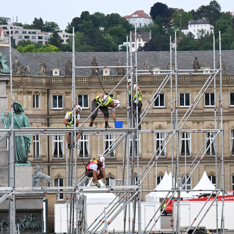 Bauarbeiter arbeiten auf einem Gerüst auf dem Schlossplatz in Stuttgart