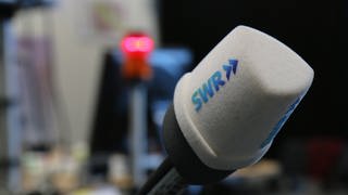 SWR Mikrofon vor unscharfem Hintergrund mit Rotlicht (Foto: SWR)