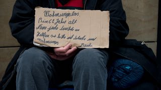 Ein Obdachloser auf Wohnungssuche hält ein Schild hoch (Foto: dpa Bildfunk, Picture Alliance)