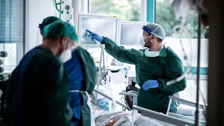 Mitarbeiter der Pflege in Schutzkleidung behandeln einen Patienten mit Corona-Infektion auf einer Intensivstation. (Foto: dpa Bildfunk, picture alliance/dpa | Fabian Strauch (Symbolbild))