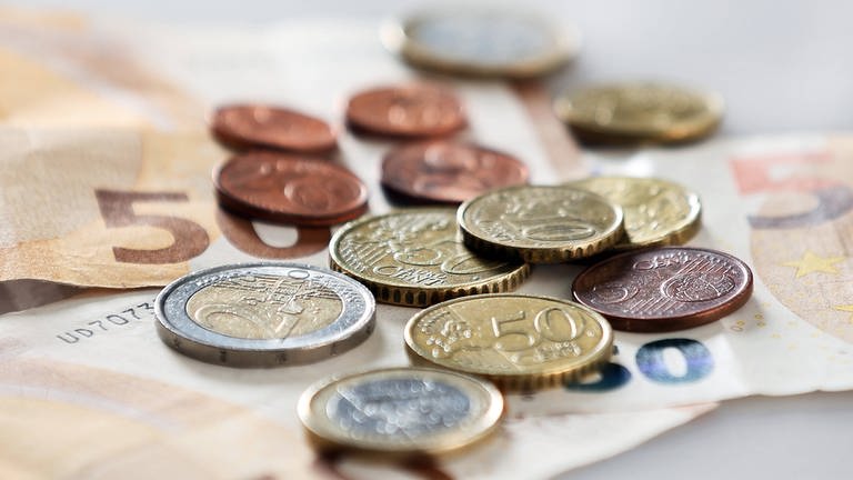 Geldscheine- und Münzen auf einem Tisch.  (Foto: IMAGO, IMAGO / avanti)