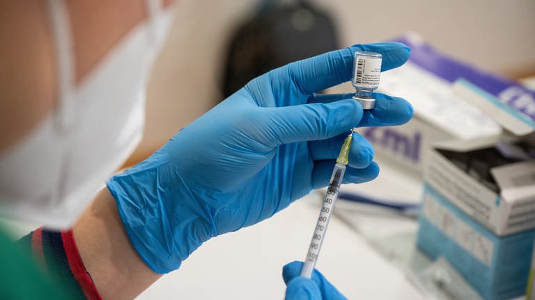 Die Mitarbeiterin eines mobilen Impfteams zieht in einem Alten- und Pflegeheim den Impfstoff von BiontechPfizer in eine Spritze auf. (Foto: dpa Bildfunk, picture alliance/dpa | Sebastian Gollnow)