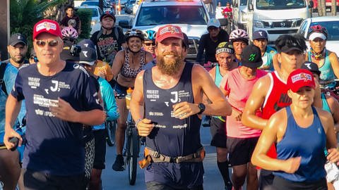 Triathlet Jonas Deichmann läuft mit einer Menschengruppe in Mexiko. (Foto: dpa Bildfunk, picture alliance/dpa/Ravir Film | ---)