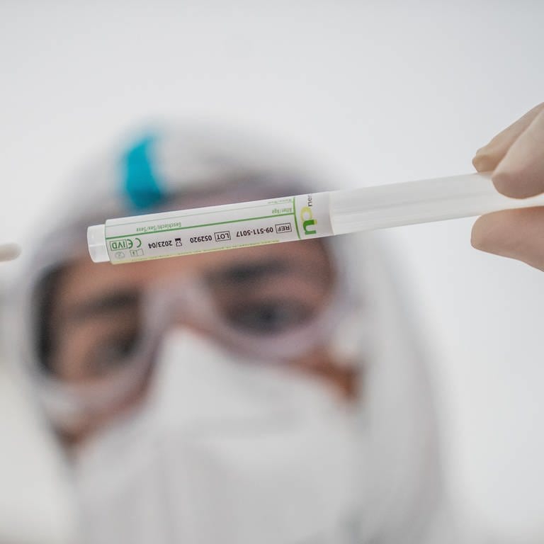 Ein Mitglied des medizinischen Personals in einem Corona-Testzentrum steckt ein Wattestäbchen nach einem PCR-Abstrich zum Test auf Covid-19 in ein Röhrchen.  (Foto: dpa Bildfunk, picture alliance/dpa | Michael Kappeler)