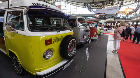 Besucher sehen sich auf der "Retro Classics" Messe in Stuttgart verschiedene alte VW-Busse an. (Foto: dpa Bildfunk, picture alliance/dpa | Christoph Schmidt)