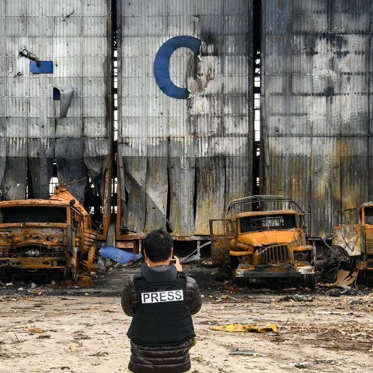 Ein Pressefotograf steht an einem zerstörten Hangar auf dem Gostomel-Flughafen in der Nähe von Kiew. (Foto: IMAGO, xMaxymxMarusenkox )