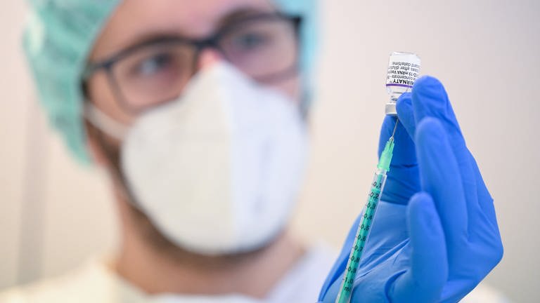 Ein Mitarbeiter des Klinikums Stuttgart bereitet eine Spritze für eine Corona Schutzimpfung vor.  (Foto: dpa Bildfunk, picture alliance/dpa | Bernd Weißbrod)