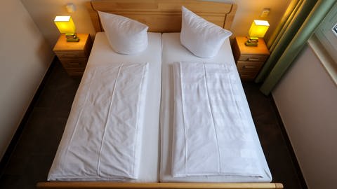 Ein Doppelzimmer in einem Hotel mit Doppelbett und zwei Nachttischen. (Foto: dpa Bildfunk, picture alliance/dpa/dpa-Zentralbild | Jan Woitas)