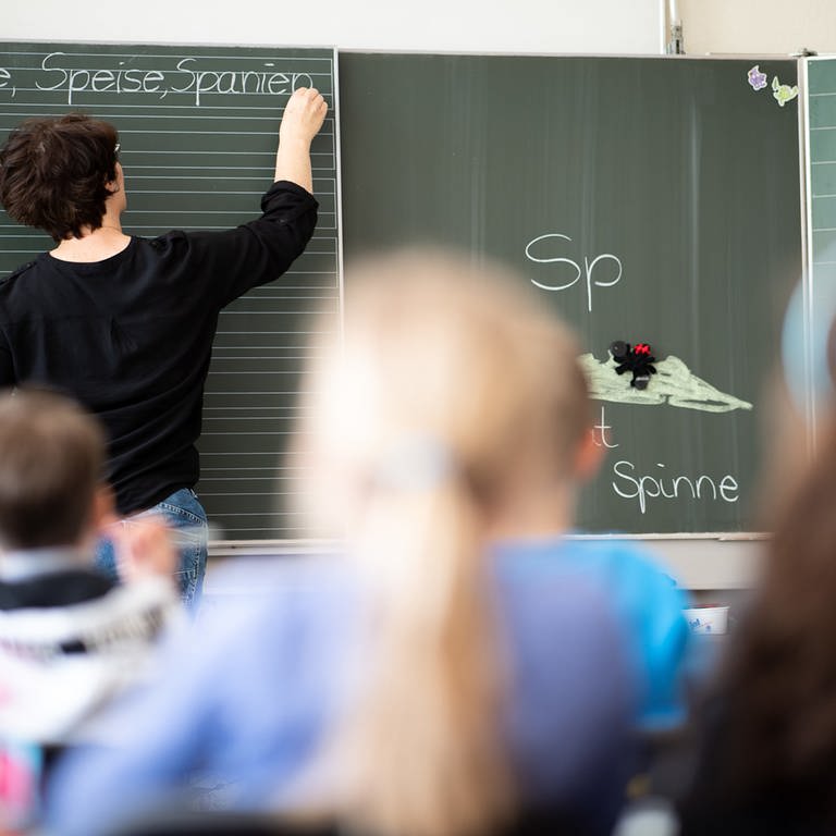 Eine Lehrerin schreibt in einer Grundschule Wörter mit "Sp" am Anfang an eine Tafel. (Foto: dpa Bildfunk, picture alliance/Sebastian Gollnow/dpa)