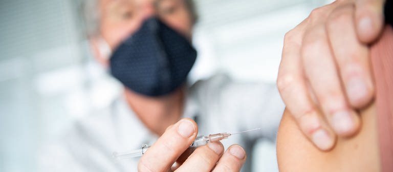 Ein Arzt impft einen Patienten gegen Grippe (Foto: dpa Bildfunk, picture alliance/Zacharie Scheurer/dpa Themendienst)